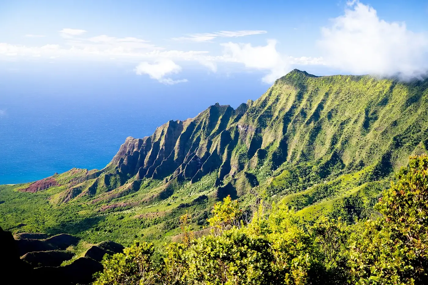 Nā Pali Coast boat tour departing Hanalei Bay on a clear day